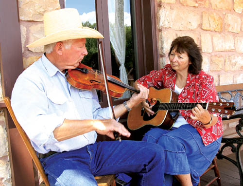 Tom and Carol Beedle, who were celebrating their 45th
wedding anniversary that day, play old-time music on the front porch of the Rock Ledge House during the Family Fourth at Rock Ledge Ranch. 
Westside Pioneer photo