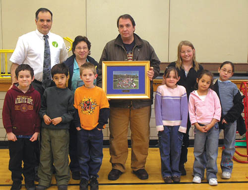 Louie�s Pizza owner Louie Sciarrotta (holding plaque) and his
wife Dawn join Pike Elementary Principal Manuel Ramsey
and students (from left) Sidney Gaylord, Cristian Medranda,
Matthew Flemming, Amber Pullara, Kimberly Loucks, Joslyn
Schwindt and Chelsey Martinez at an assembly Jan. 17 in which the businessman was thanked for donating monthly pizzas to the school for many years.
Hillary Pohlmann photo