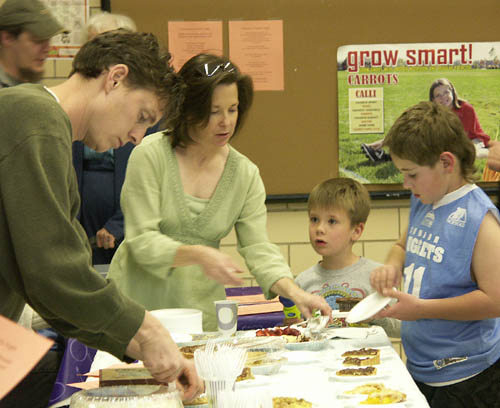 Parent volunteers Lynne Casebeer (left) and Liz Kinney help
students Evan Kinney (second from right) and Zach New get
their just desserts at the Buena Vista Art & Pie Night April 
17. 
Westside Pioneer photo