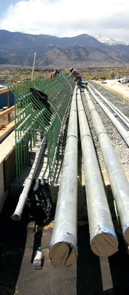 Beneath a vista of Pikes Peak, Cimarron bridge workers tidy
up recently laid rebar this week, while standing on conduits
for electrical and fiber lines that will run beneath the bridge�s sidewalk. 
Westside Pioneer photo