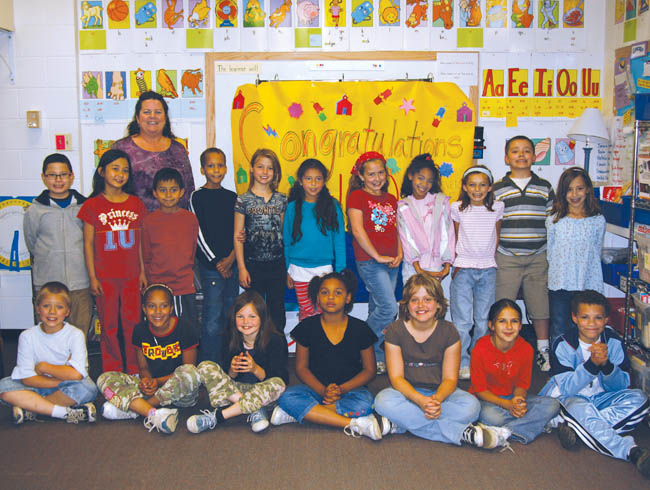 Pike Elementary teacher Maureen Breckenridge and her
third-grade class pose in front of a banner that says
Congratulations  100. The number recognizes the students perfect CSAP reading score. 
Westside Pioneer photo