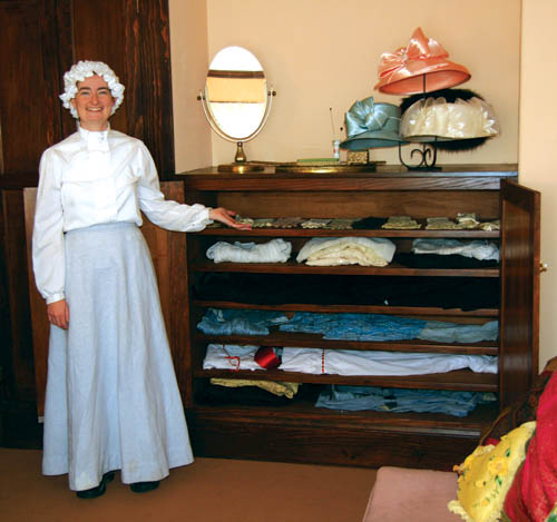Dressed in period attire, Beth Harmon shows a cabinet that
was built for a restored Orchard House second-floor
dressing room. A docent for 12 years, Harmon served over
the past several months as interim interpreter for Rock
Ledge Ranch, but is now studying to be a physician�s
assistant at CU Health Sciences in Denver. Elizabeth Barber, another long-time docent, recently took on the interpreter duties.
Westside Pioneer photo