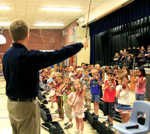 Michael Hanson of the Colorado Springs Philharmonic
Orchestra, Bristol Elementary�s Suzuki violin teacher,
readies some of his youngest students for a song as part of the afternoon Honor Concert May 20 in the school gym. There was another concert in the evening.
Westside Pioneer photo