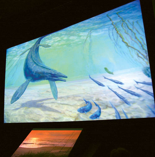  A prehistoric fish swims in an ocean that once swirled where the Garden of the Gods stands during the new version of the  
Visitor Center movie, �How Did Those Red Rocks Get There?� Below the main screen is the supplemental periaktoi screen device.
Westside Pioneer photo