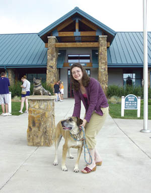 Ann Hagerty of the Humane Society of the Pikes Peak
Region stands in front of the building with Tanner, a German Shepherd up for adoption.