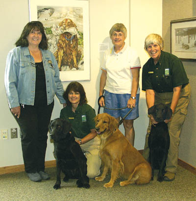 Enjoying the dog-art exhibit (and standing in front of a
1991 painting by area artist Mary Helsaple titled The
Father of All Retrievers) are (from left) Helsaple; Nature
Center interpretive specialist Paula Megorden and her dog,
Evie Wonder; Sarah Smith and her dog, Maggie; and Bear
Creek Nature Center Director (also the collection owner) Donna Scheeter and her dog, Ali Bubba, at the centers Dog Days art show opening Aug. 5.
Westside Pioneer photo