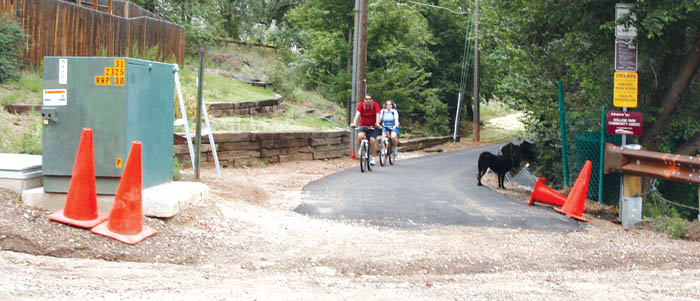 Westbound bicyclists  approach Holland Park Boulevard from the Douglas Creek Open Space�s Sinton Trail this 
week. Someone had pushed aside the city�s �Trail Closed� sign at that location at the time, but many people have been using the newly paved trail anyway.
Westside Pioneer photo