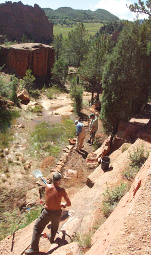 Eric Brettschneider tosses a shovelful of dirt to a lower level
 at the quarry crossing; above: volunteers gather crusher fines to raise a low section of trail