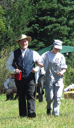 Scenes from the vintage baseball game played at Rock Ledge Ranch Historic Site Labor Day, Sept. 3 ...
Umpire Andy Red Regan escorts Abbey Husker Dorman to first base after she drew the only walk of the game (an achievement that required the hurler to deliver 
five bad pitches).
Westside Pioneer photo