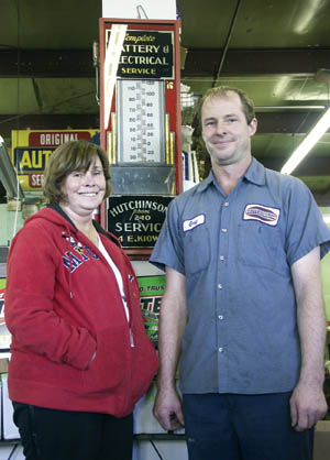 Hutchinson Battery owners Greg and Cheryl Berce stand in front of a business-name thermometer from the early days 
when Hutchinson had the 240th phone number in Colorado Springs.
Westside Pioneer photo