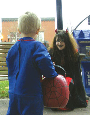 Kirstin Harbert of the Widefield High Debating Team (which
had been given a stipend to help hand out candy to kids)
 tries to convince a cautious young trick-or-treater she's a
good demon during the Halloween Safe Treats in Old Colorado City Oct. 31.
Westside Pioneer photo