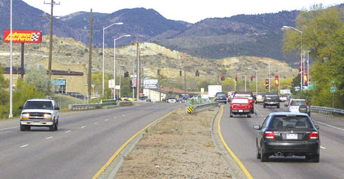 Traffic is shown on the current four-lane Highway 24
looking west toward the 21st Street intersection. The
Advance Auto Parts store (the sign for which is at left)
would be at risk in the widening, while, according to CDOT
officials, Van Briggle Pottery (beyond in the tan building at 
left) would be preserved because it is in a historic building.
Westside Pioneer photo
