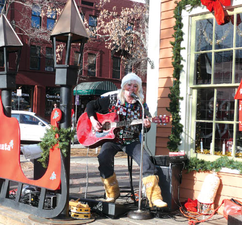 Jan Dixon performs outside the Garvin Cabin (decked out for Santa during the Christmas season), as part of the 
�Holiday Magic� festivities Nov. 28.
Westside Pioneer photo